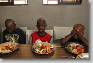From left, Winsky Otilus, Wilky Maignant and Zikansley Sima say a prayer before lunch at the Yahve-Jire Children's Foundation in Tabarre,  Haiti Tuesday May 4, 2010.  The orphanage is supported by Western Boulevard Presbyterian Church.  ETHAN HYMAN  - ehyman@newsobserver.com