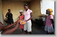 Daphanee Desir gets breakfast from Resimene Joseph at the Yahve-Jire Children's Foundation in Tabarre,  Haiti Wednesday May 5, 2010.  The orphanage is supported by Western Boulevard Presbyterian Church.  ETHAN HYMAN  - ehyman@newsobserver.com