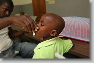 Managing Director Chedlin Justinvil gives Yvanov August  tylenol as he had a fever at the Yahve-Jire Children's Foundation in Tabarre,  Haiti Wednesday morning May 5, 2010.  The orphanage is supported by Western Boulevard Presbyterian Church.  ETHAN HYMAN  - ehyman@newsobserver.com