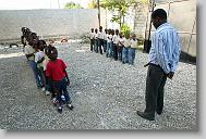 Hendel Ulysse, director of the school, leads the children in prayer at the start of school at the Yahve-Jire Children's Foundation in Tabarre,  Haiti Wednesday May 5, 2010.  The orphanage is supported by Western Boulevard Presbyterian Church.  ETHAN HYMAN  - ehyman@newsobserver.com