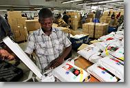 Rubian Carmiso seals t-shirts at AGA Corp. in Port au Prince Wednesday May 5, 2010.  The plant produces over one million men's t-shirts a week.  ETHAN HYMAN  - ehyman@newsobserver.com