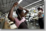 Guillaume Anaitare blows the dust out of her hair at the end of shift at  AGA Corp. in Port au Prince Wednesday May 5, 2010.  The plant produces over one million men's t-shirts a week.  ETHAN HYMAN  - ehyman@newsobserver.com